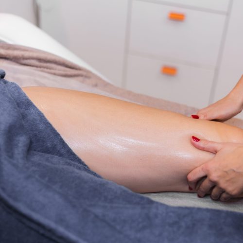 Masseur doing manual massage to client in spa beauty salon using oil